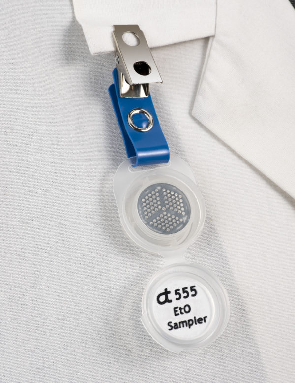 Assay Technology 555 Ethylene Oxide Monitor badge clipped to collar